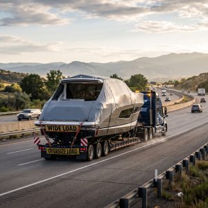 Boat Hauling Companies moving a wide-beam cruiser on a trailer as permit delays shape interstate yacht transport schedules